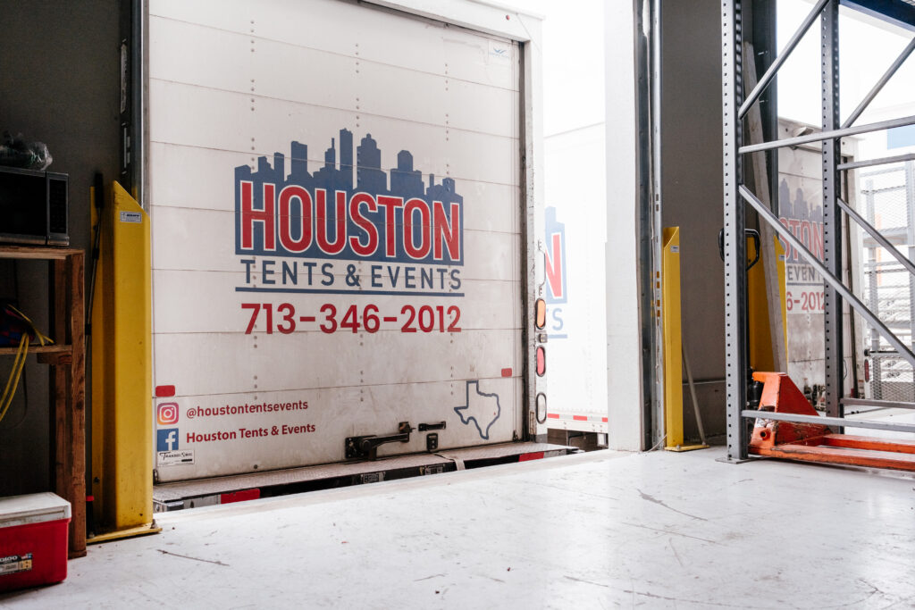 The rear of a delivery truck featuring the logo of Houston Tents & Events, with a graphic of the Texas outline and city skyline.